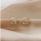 Goldene Spiral-Ohrstecker mit Blüten und Kristall - Haller